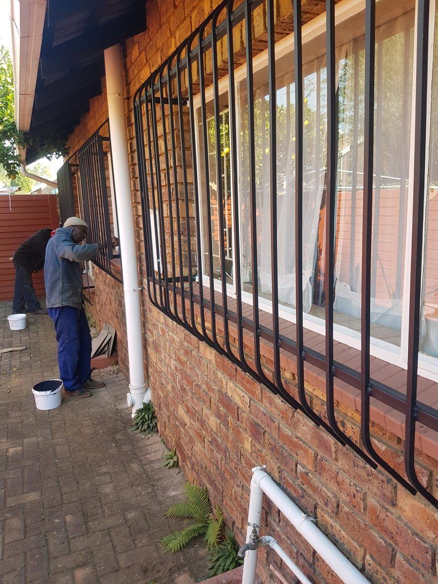 Burglar bars being installed and painted on a house in Pretoria