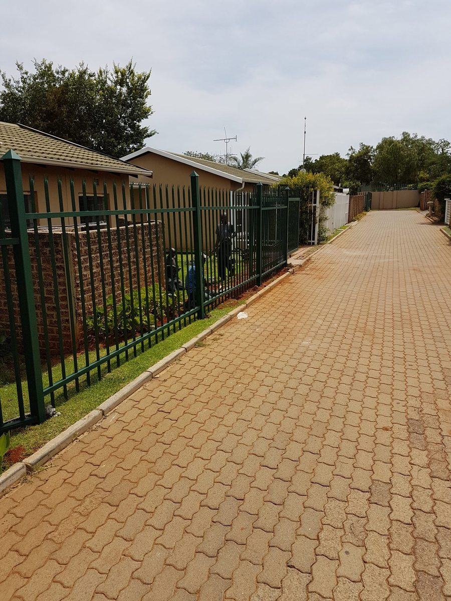 Palisade fencing along a paved walkway in Pretoria